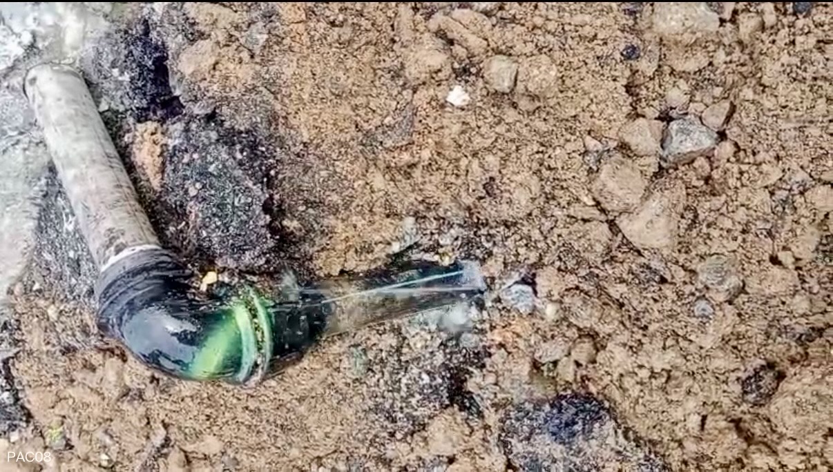 Contractor follow-up image showing water escaping from an exposed pipe connection after excavation at the marked location.